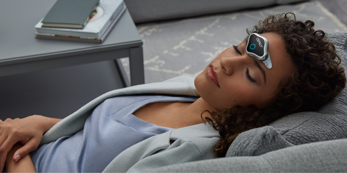 woman with migraine laying down with CEFALY device on forehead