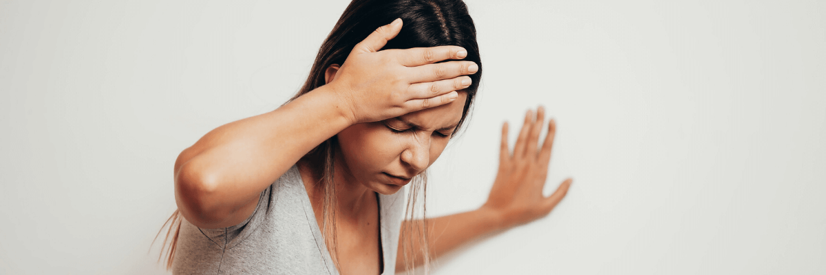 Managing Migraine in Pregnancy: Your Questions Answered A woman holding her head in pain, experiencing a migraine.